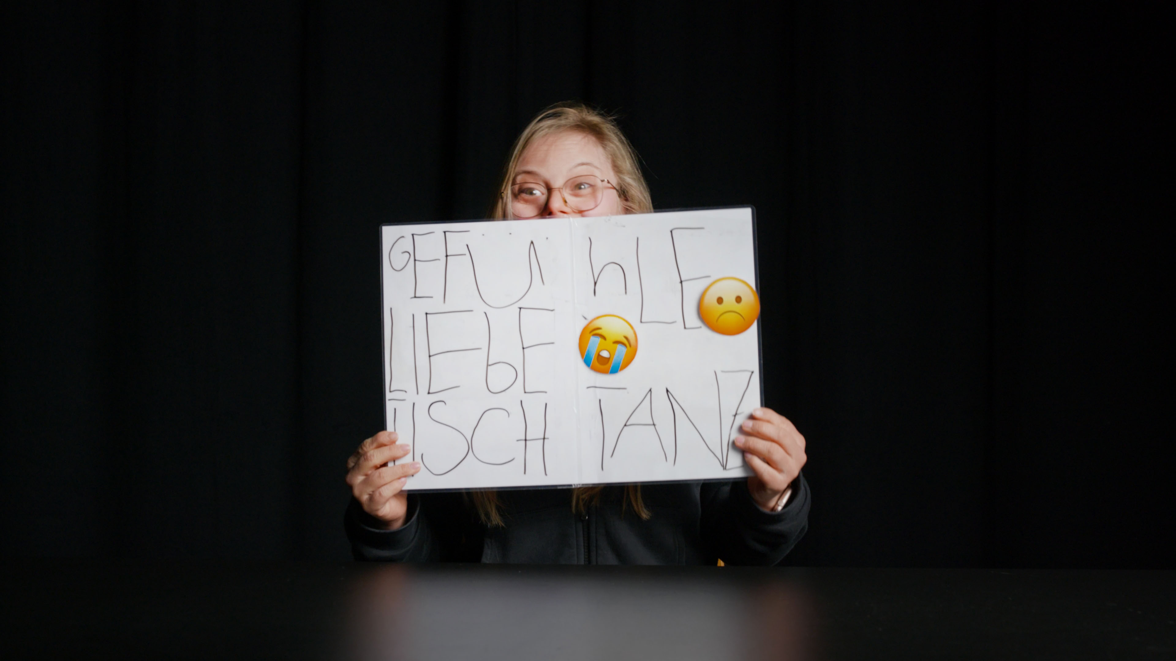Schauspielerin des Theater HORA zeigt eine gezeichnete Tafel