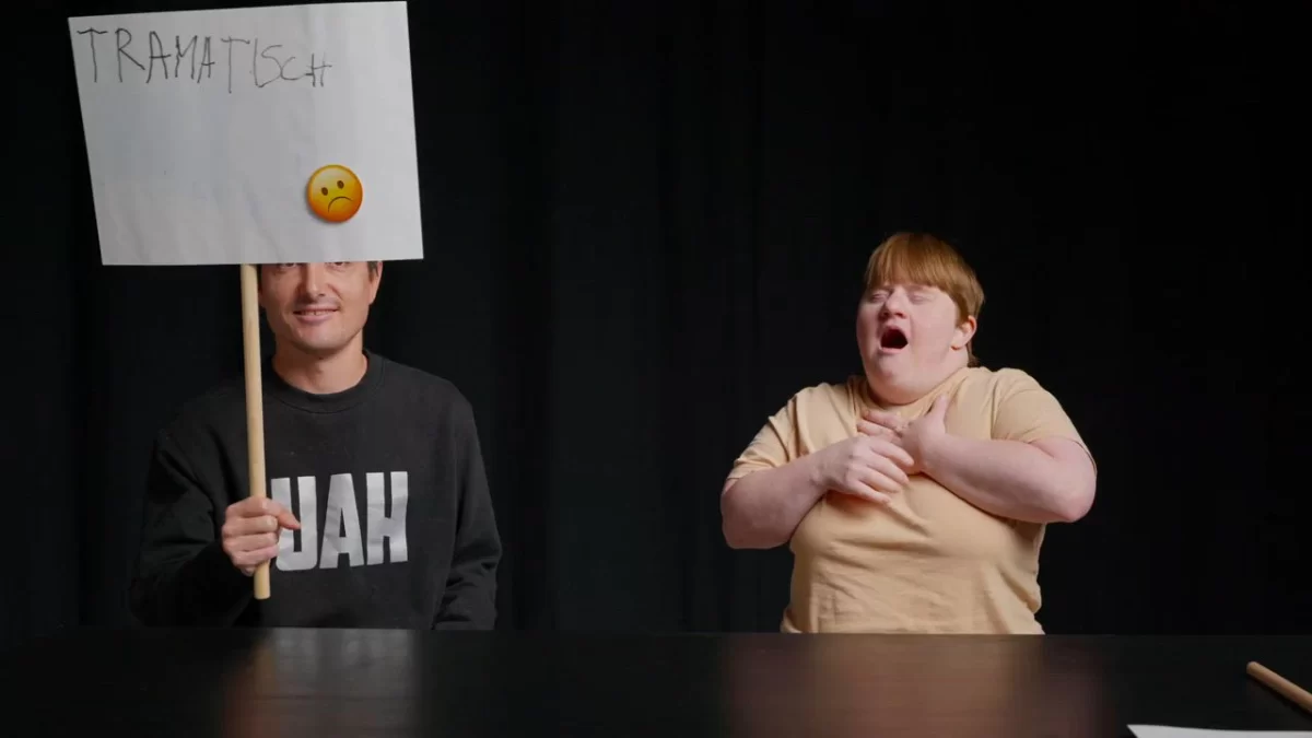 Zwei Schauspieler:innen des Theater HORA zeigen handgeschriebene Tafeln