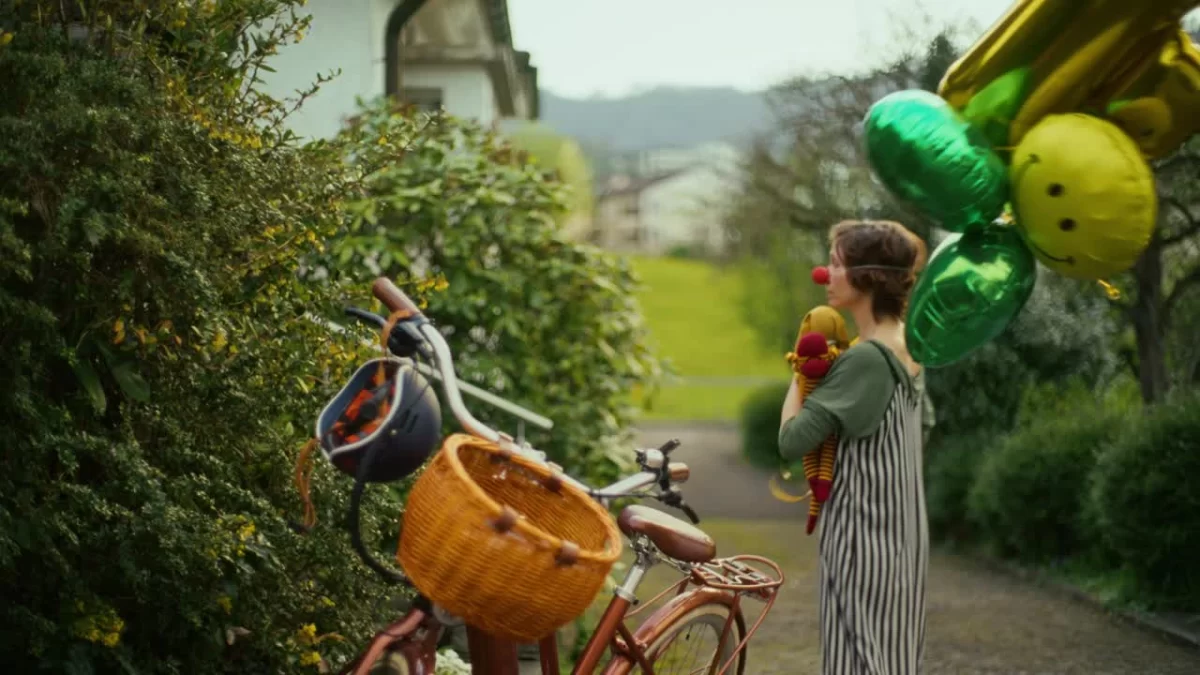Pantomime begegnet einer Person mit E-Bike in einer sommerlichen Strasse